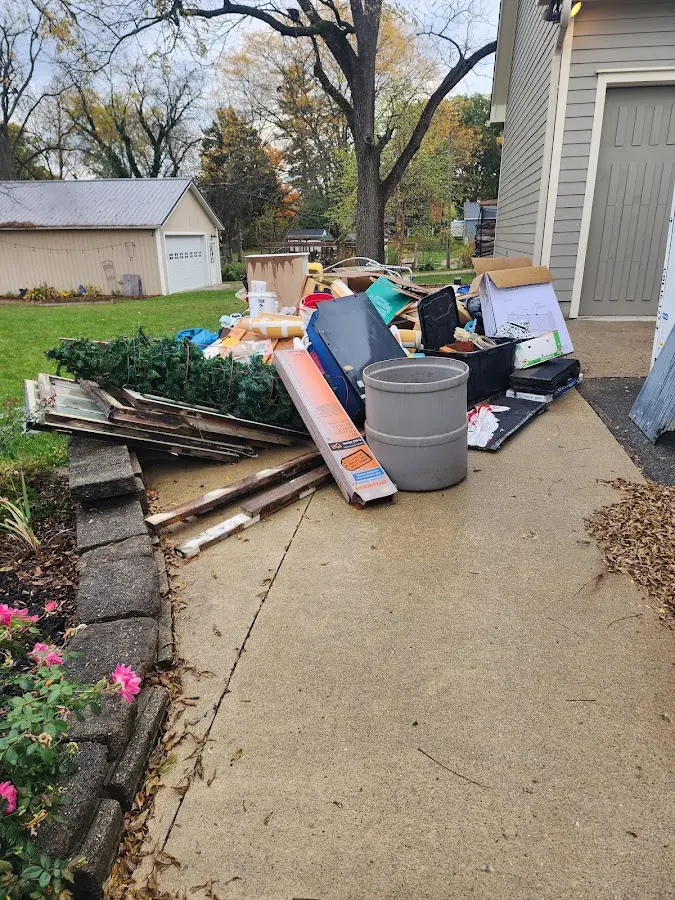 Dumpster being loaded with debris for 12 Yard Dumpster Rental in Bryan